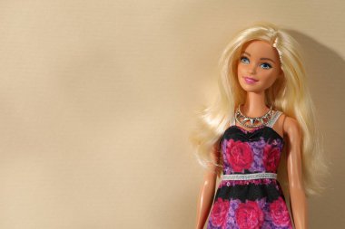 Mykolaiv, Ukrayna - 4 Eylül 2023: Bej arka planda kolye takan güzel Barbie bebek, metin için yer