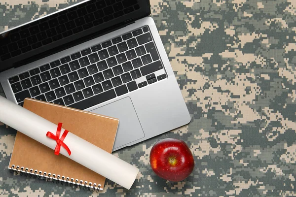 Notebook, diploma, laptop and apple on camouflage background, flat lay with space for text. Military education