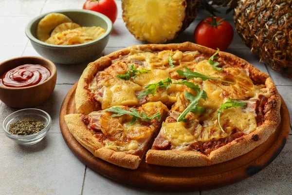 Delicious cut pineapple pizza on light gray table, closeup