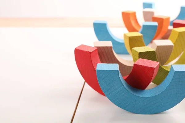 Motor skills development. Colorful wooden pieces of playing set on white table, closeup. Space for text
