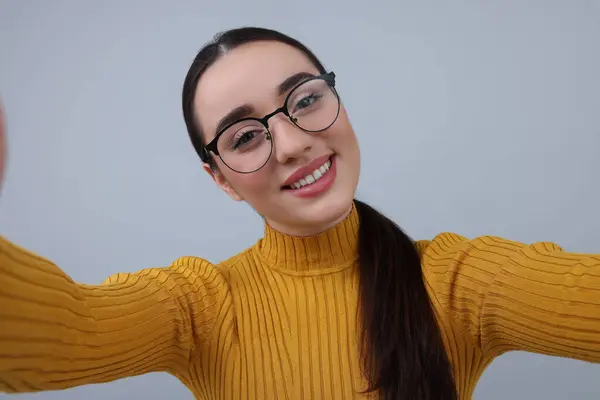 Uśmiechnięta Młoda Kobieta Robi Selfie Szarym Tle — Zdjęcie stockowe