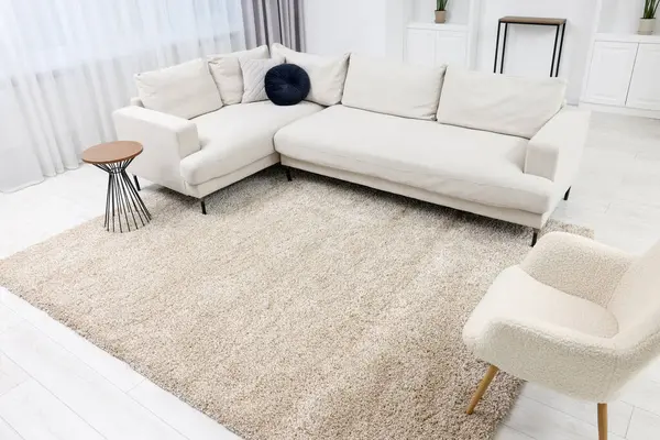 Fluffy carpet and stylish furniture on floor indoors