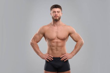 Açık gri arka planda yakışıklı kaslı adam. Seksi vücut.