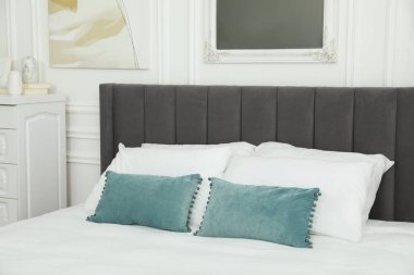 Yatak odasında yastıklar olan büyük, rahat bir yatak. İç tasarım