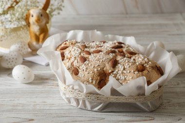 Lezzetli İtalyan Paskalya güvercini pastası (geleneksel Colomba di Pasqua) ve beyaz ahşap masa üzerinde süslü yumurtalar.