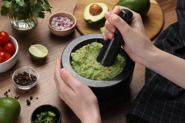 Ahşap masada nefis guacamole hazırlayan kadın, yakın plan.