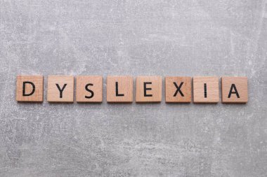 Açık gri taş masa üzerinde kelime disleksisi ile tahta kareler, düz yatıyordu