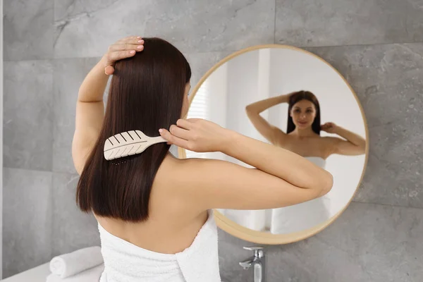 Όμορφη Γυναίκα Βουρτσίζει Μαλλιά Της Κοντά Στον Καθρέφτη Στο Μπάνιο — Φωτογραφία Αρχείου