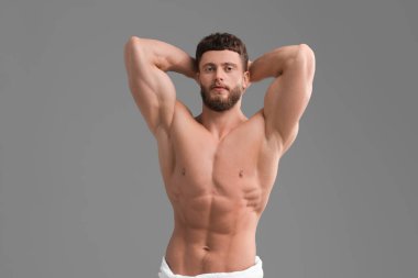 Gri arka planda yakışıklı kaslı adam. Seksi vücut.
