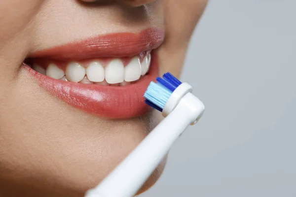 Γυναίκα Βουρτσίζει Δόντια Της Ηλεκτρική Οδοντόβουρτσα Λευκό Φόντο Κοντινό Πλάνο — Φωτογραφία Αρχείου