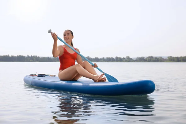 Woman paddle boarding on SUP board in sea