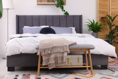 Çift kişilik yatağı ve güzel yeşil çiçekleri olan şık bir yatak odası. Modern iç mimari