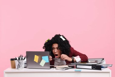 Son teslim tarihi stresli. Pembe arka planda dizüstü bilgisayara bakan korkmuş bir kadın. Mesaj için yer var. Hatıra olarak her yerde yapışkan notlar var.