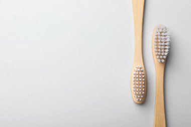 Hafif arka planda bambu diş fırçaları, düz yatış. Metin için boşluk
