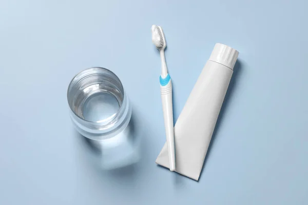 Plastic Toothbrush Paste Glass Water Light Background Flat Lay — Stock Photo, Image