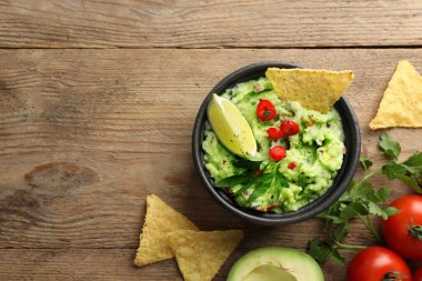 Nachos cipsi ve ahşap masa üzerindeki malzemelerle nefis guacamole. Metin için boşluk