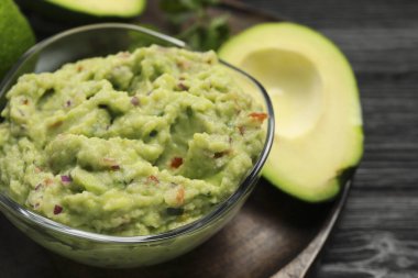 Lezzetli guacamole ve taze avokado ile cam kase, yakın plan. Metin için boşluk