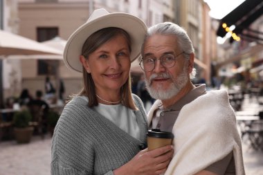 Sevecen son sınıf çifti dışarıda kahve içerken, mesaj atmak için yer ararken.