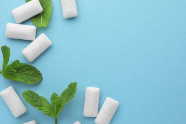 Lezzetli beyaz sakız ve açık yeşil arka planda nane yaprakları, düz yatış. Metin için boşluk