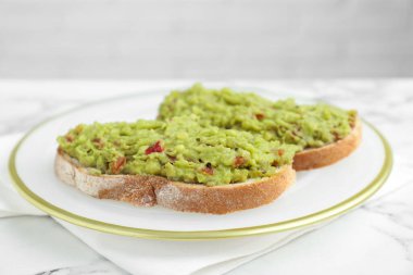 Guacamole soslu lezzetli sandviçler beyaz masada, yakın plan.
