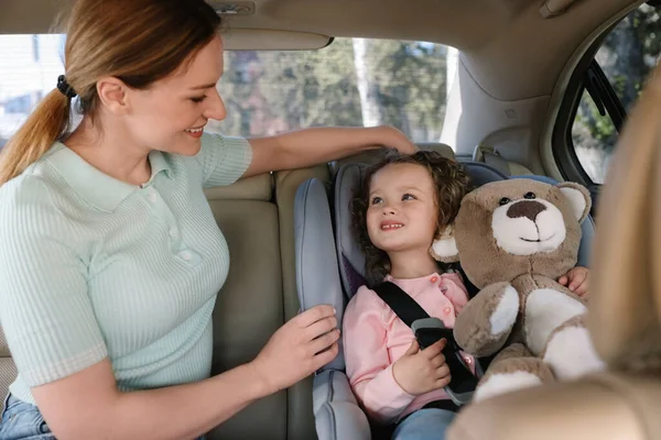 Schattig Klein Meisje Met Teddybeer Zittend Kinderzitje Bij Moeder Auto — Stockfoto