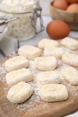 Tembel börekler yapıyorum. Kesik hamurlu ahşap tahta ve un, yakın plan.