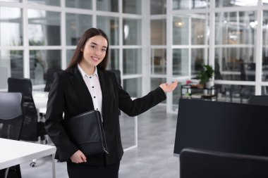 Ofisinde deri portföyü olan mutlu bir emlakçı.