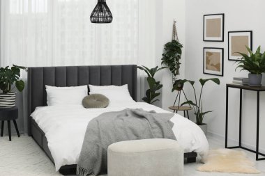 Büyük, rahat bir yatak ve güzel bitkiler. Yatak odasının içi.