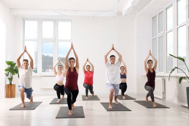 Paspaslar üzerinde yoga yapan bir grup insan.