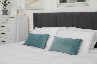 Yatak odasında yastıklar olan büyük, rahat bir yatak. İç tasarım