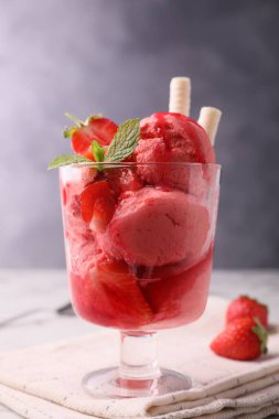 Lezzetli çilekli dondurma, taze böğürtlenli ve gofretli gofret, masada cam tatlı kasesi, yakın plan.