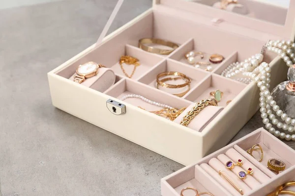 浅灰桌子上有许多不同配件的珠宝盒 — 图库照片