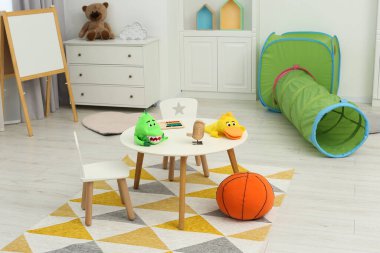 Child`s playroom with different toys and modern furniture. Stylish kindergarten interior clipart