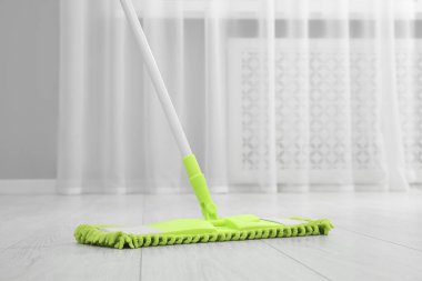 Kirli ahşap zemini paspasla temizliyorum.