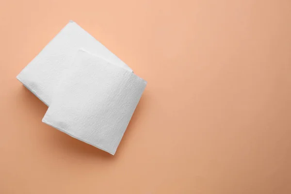 Stack of clean paper tissues on beige background, top view. Space for text