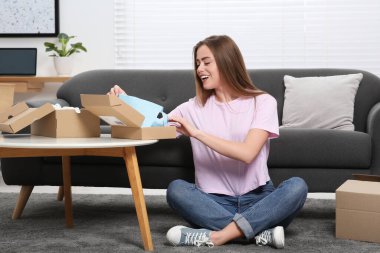 Evde paketleri açan duygusal bir kadın. Çevrimiçi mağaza