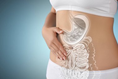 Açık mavi arka planda sağlıklı sindirim sistemi olan bir kadın, yakın plan. Gastrointestinal sistemin bir yansıması.
