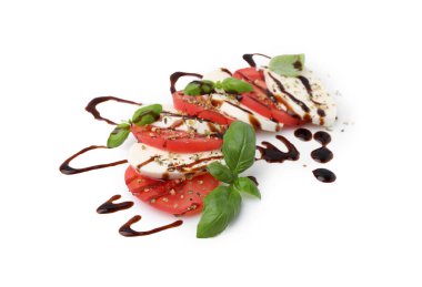 Beyaz arka planda mozzarella, domates, fesleğen ve sos ile lezzetli salata Caprese.