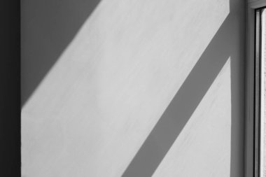 İçerideki bej duvardaki pencerenin gölgesi