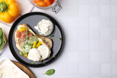 Burrata peynirli lezzetli sandviç, prosciutto, sebze ve malzemeler beyaz fayanslı masa, düz yatak. Metin için boşluk
