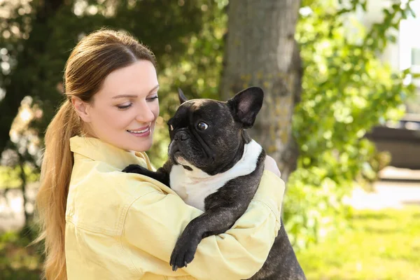 Happy woman with cute French Bulldog outdoors
