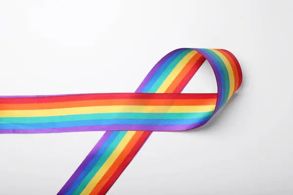 Rainbow ribbon on white background, top view. LGBT pride