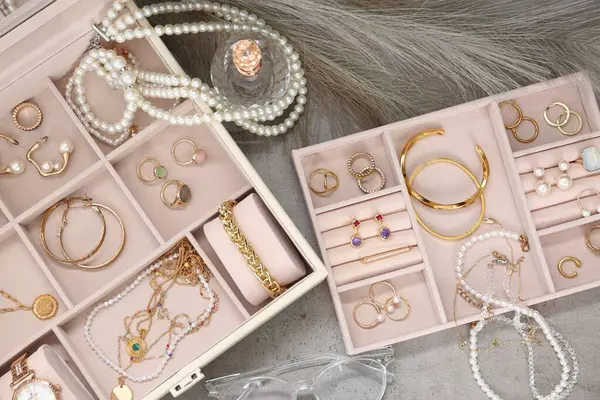 浅灰桌子上有许多不同配饰 眼镜和香水的珠宝盒 — 图库照片