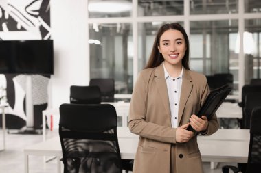 Ofisinde deri portföyü olan mutlu bir emlakçı.