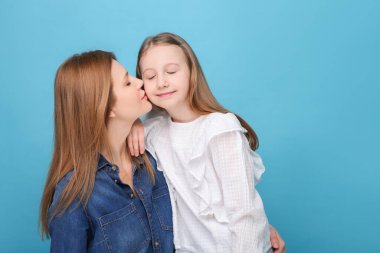 Açık mavi arka planda anne ve tatlı kızının portresi. Metin için boşluk