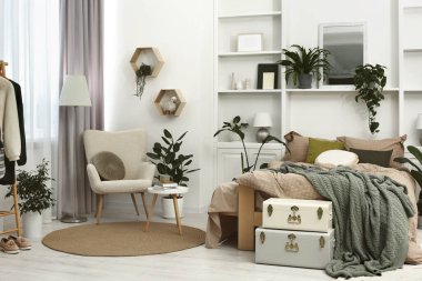 Rahat yatağı ve farklı bitkileri olan şık bir yatak odası. İç tasarım