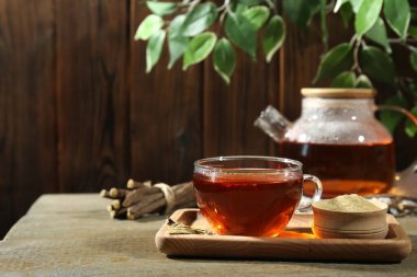 Bardakta Aromatik meyan kökü çayı ve tahta masada pudra, metin için yer