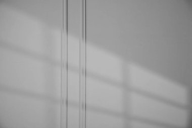 İçerideki koyu gri duvardaki pencerenin gölgesi