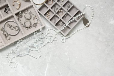 Açık gri masa üzerinde bir sürü farklı aksesuar bulunan mücevher kutuları. Metin için boşluk