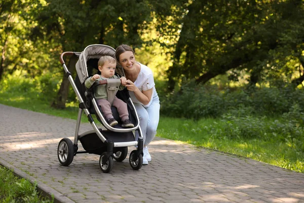 Mutlu dadı ve şirin çocuk parkta bebek arabasında, mesaj için yer var.